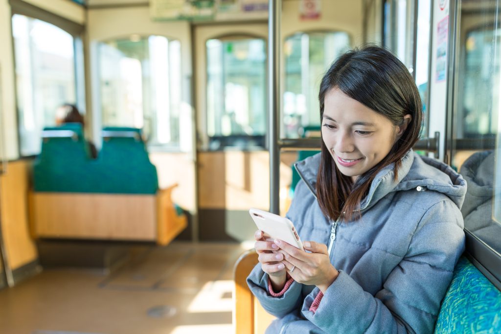 Employer Branding in Mainz: junge Frau mit Smartphone in der Straßenbahn